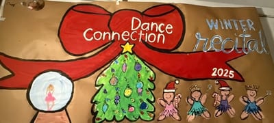 Hand-painted winter dance recital banner with white Dance Connection lettering on a red bow, a decorated Christmas tree, ballerinas in Santa hats and tutus, and a snow globe with a dancer inside