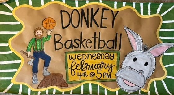 Hand-painted community event banner with a lumberjack character spinning a basketball, a donkey face, green and brown colors, and a border with event details